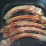 Look's Meat Market cooking Benton's bacon 1st flip