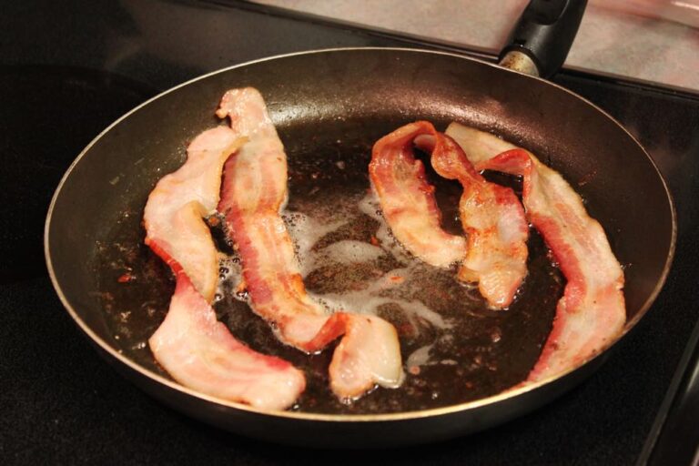 American style bacon cooking in a pan