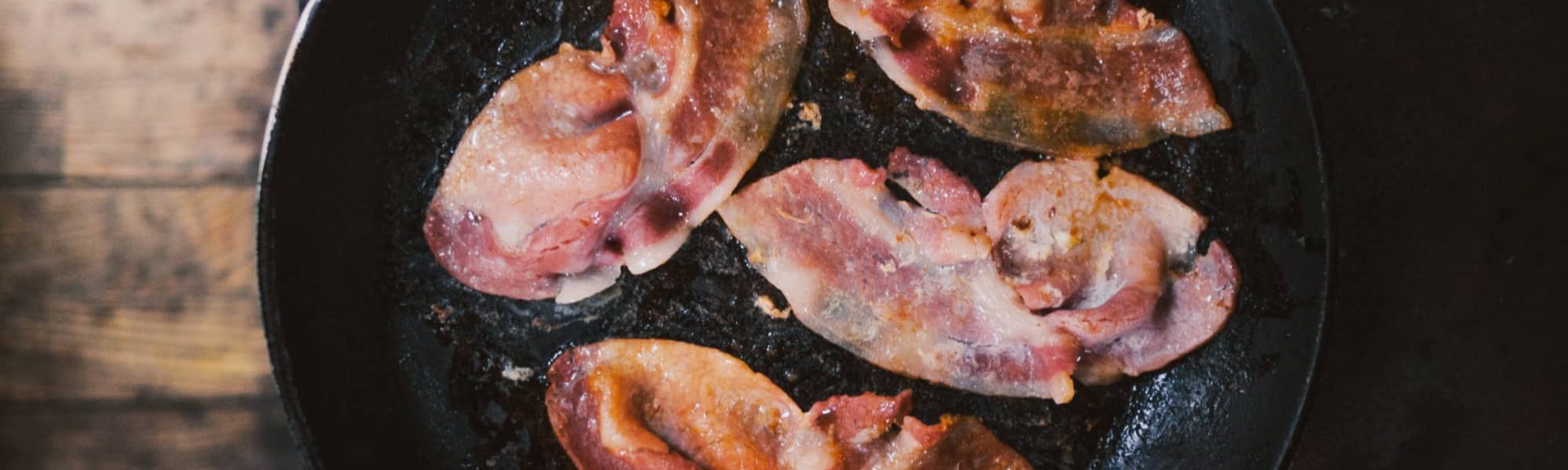 Delicious bacon frying in a pan