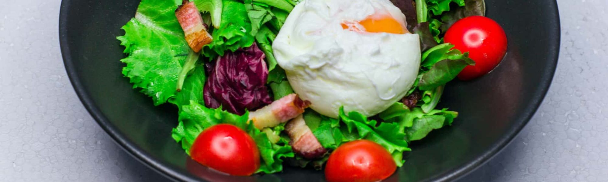 Example of bacon in a diabetic meal. Salad with bacon chunks and egg.